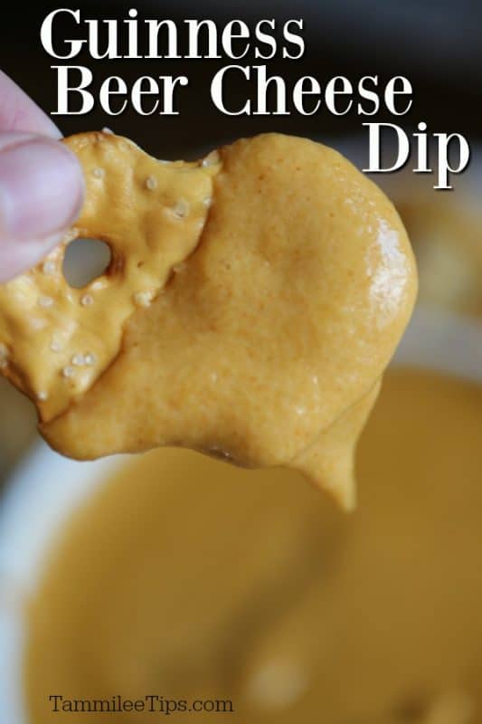 Guinness Beer Cheese Dip on a pretzel chip above a bowl 