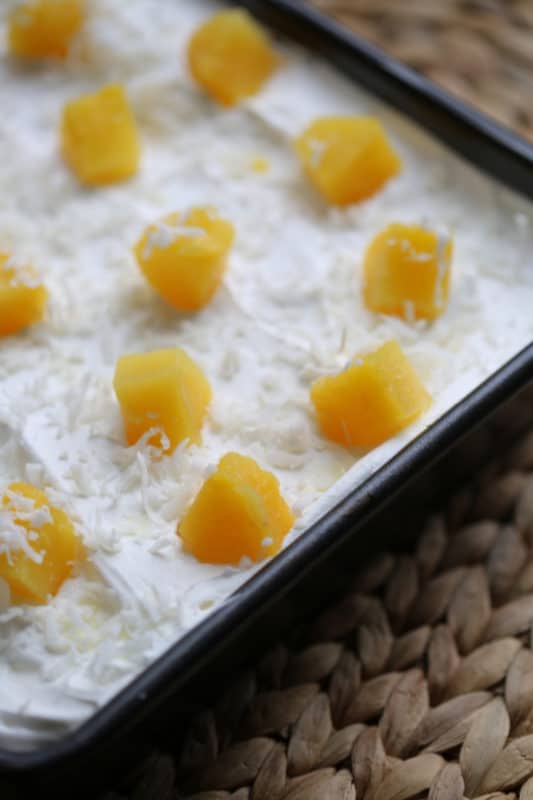 Pina colada cake topped with coconut and pineapple chunks