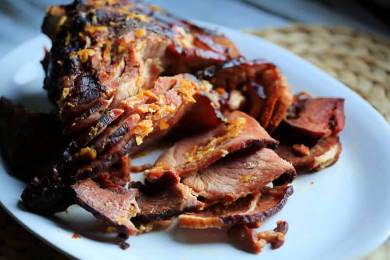 spiral ham with orange zest on a white platter