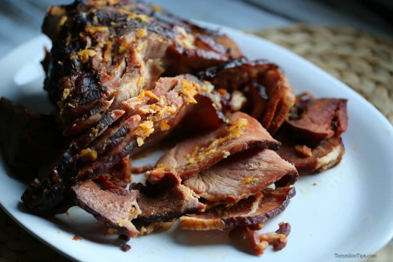 Orange Glazed ham with orange zest on a white plate