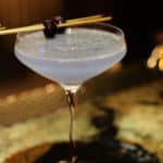 Aviation cocktail in a martini glass with cherry garnish