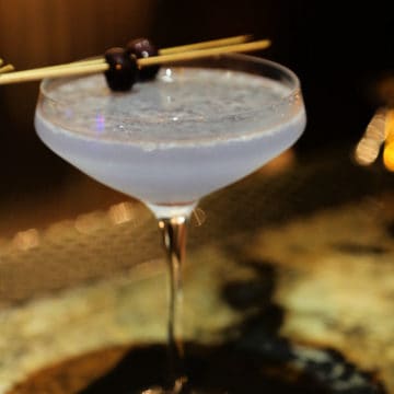Aviation cocktail in a martini glass with cherry garnish