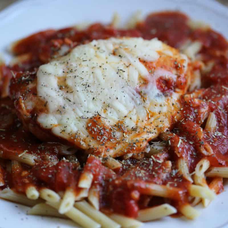 Chicken Parmesan Crock Pot on a white plate topped with sauce and cheese