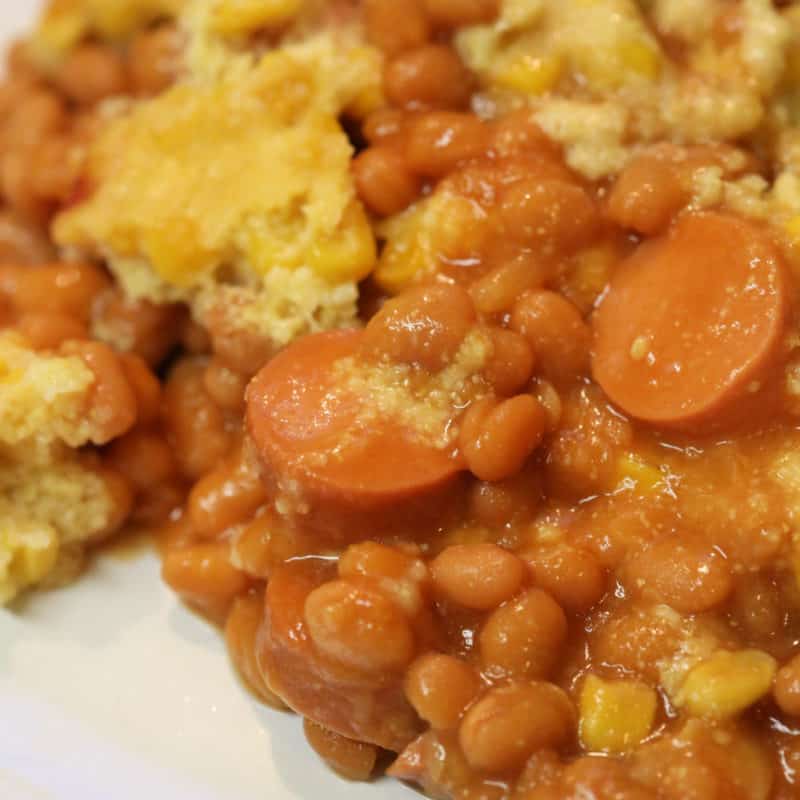 corn dog casserole with baked beans on a white plate
