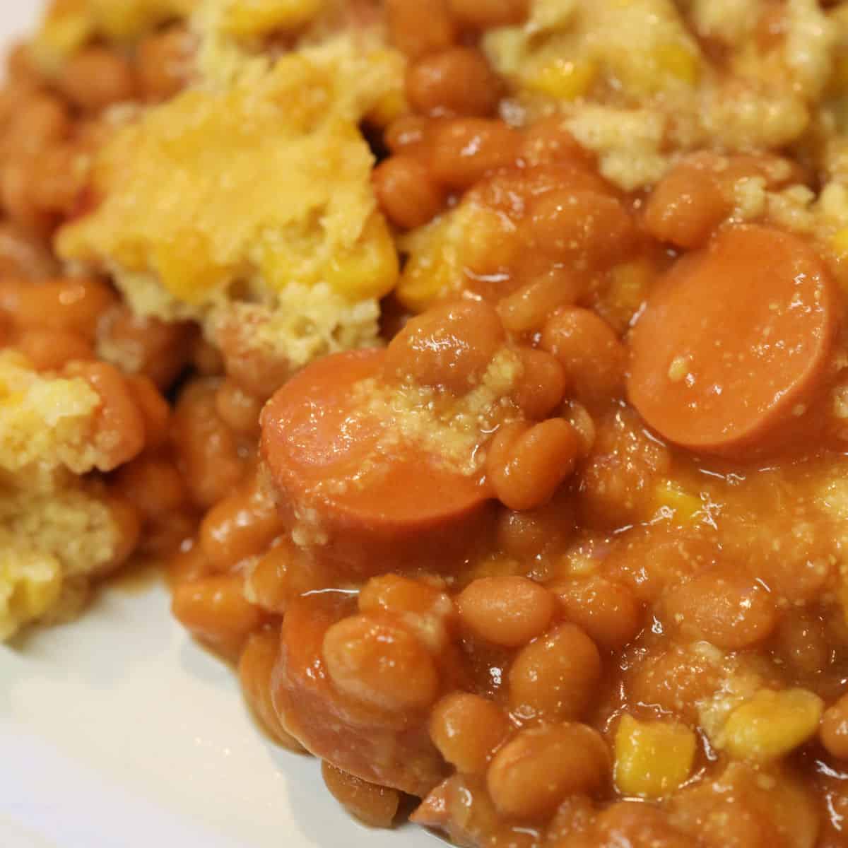 corn dog casserole with baked beans on a white plate