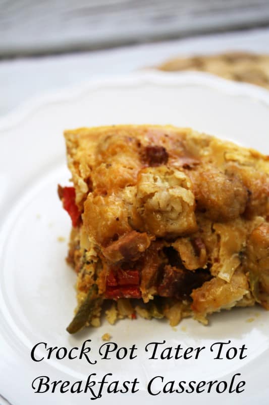 Crock Pot Tater Tot Breakfast Casserole under a white plate with a piece of breakfast casserole on it