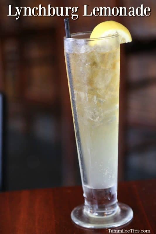 Lynchburg Lemonade in a tall glass with a slice of lemon on it sitting on a wood table