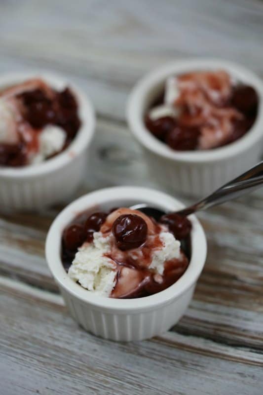 Cherry Pie Moonshine over vanilla ice cream in a small bowl with a spoon