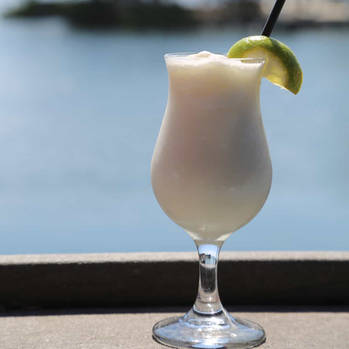 Key Lime Colada in a hurricane glass with lime wedge garnish