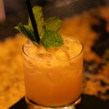 mai tai cocktail with a mint leaf garnish in a rocks glass