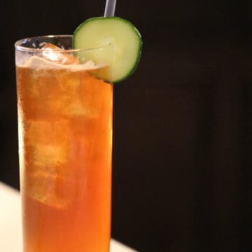 Pimm's Cup in a tall glass with cucumber wheel garnish