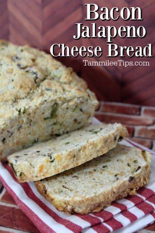 Bacon jalapeno cheese bread over a loaf of sliced bread on a rd striped napkin