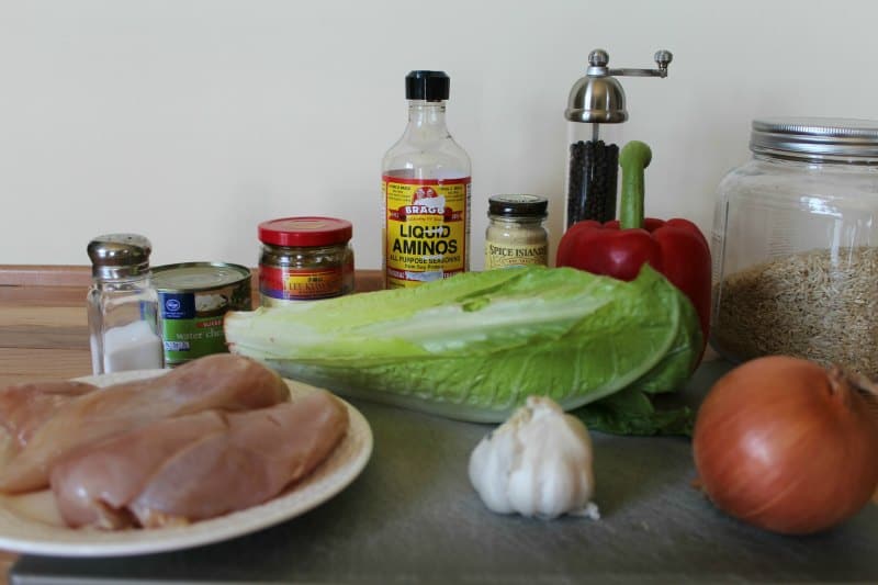 chicken, lettuce, garlic, onion, spices on a wood cutting board