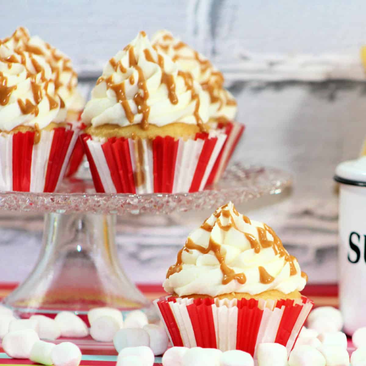 Fluffernutter Cupcake on a cake stand surrounded by mini marshmallows