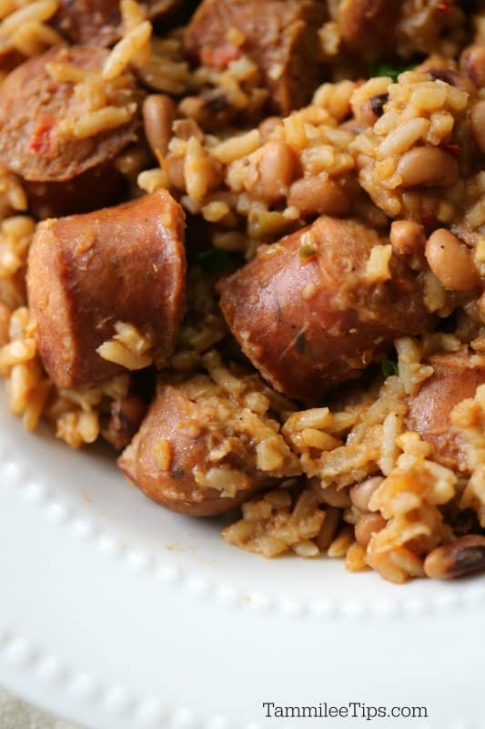  a white plate piled high with rice, kielbasa, and more. 