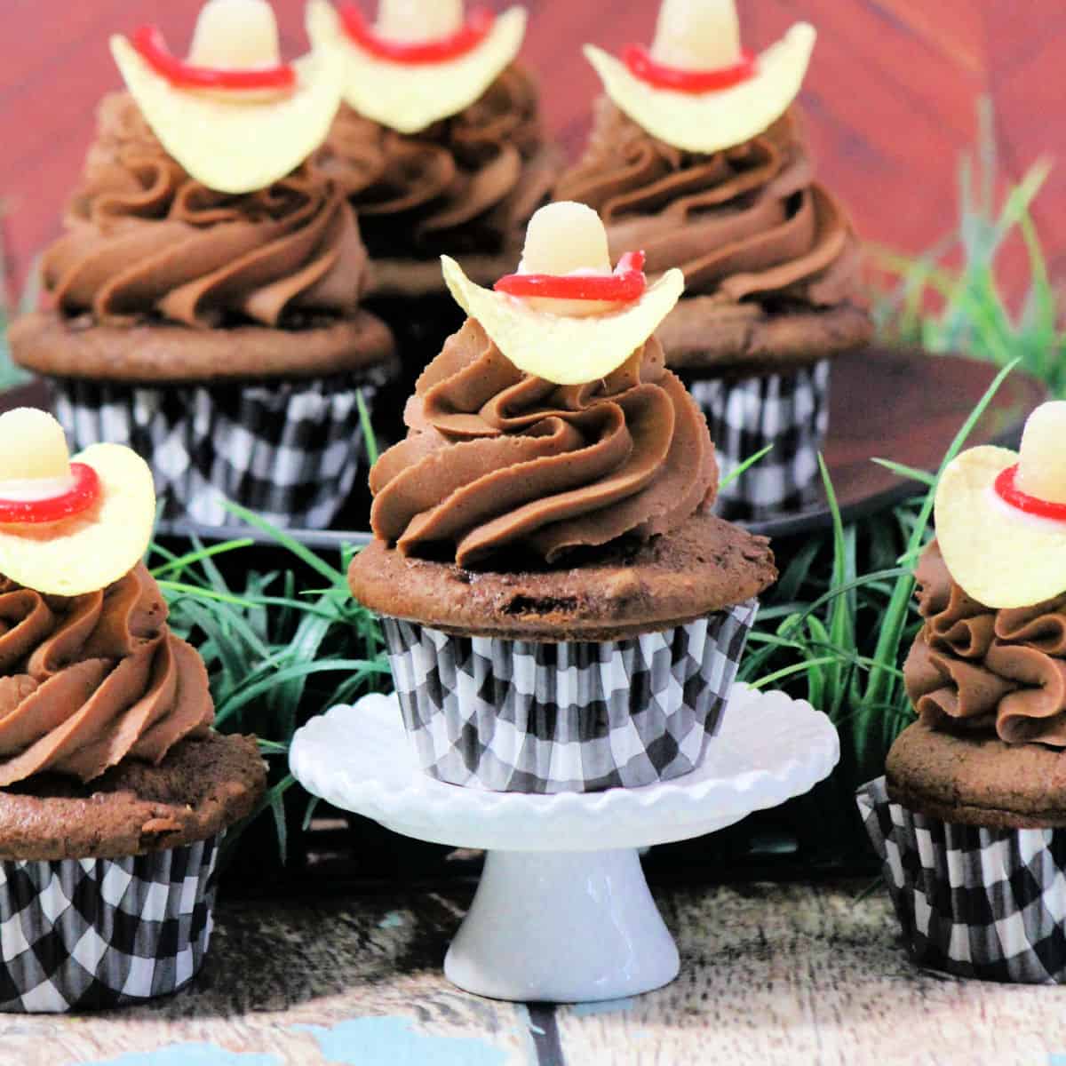 Cowboy Hat Cupcake on a cupcake stand surrounded by more cupcakes