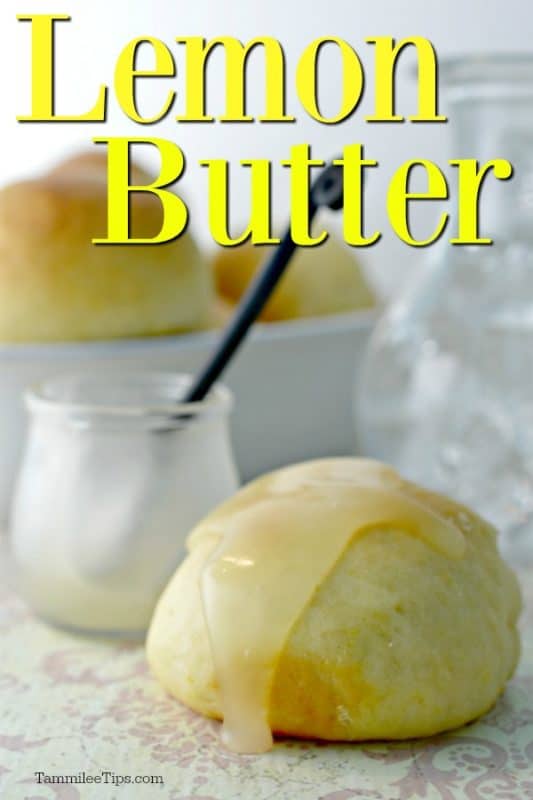 Lemon butter over a roll covered in butter with a jar in the background. 