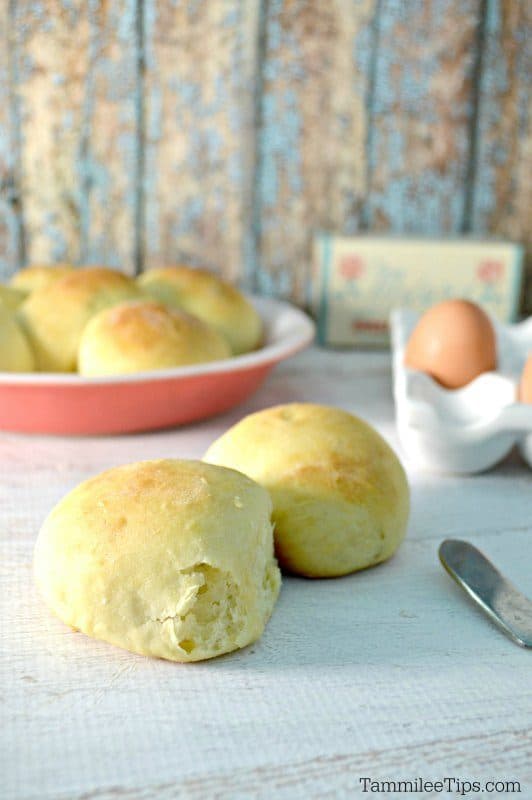 Sweet bread rolls near a knife, eggs, and more rolls