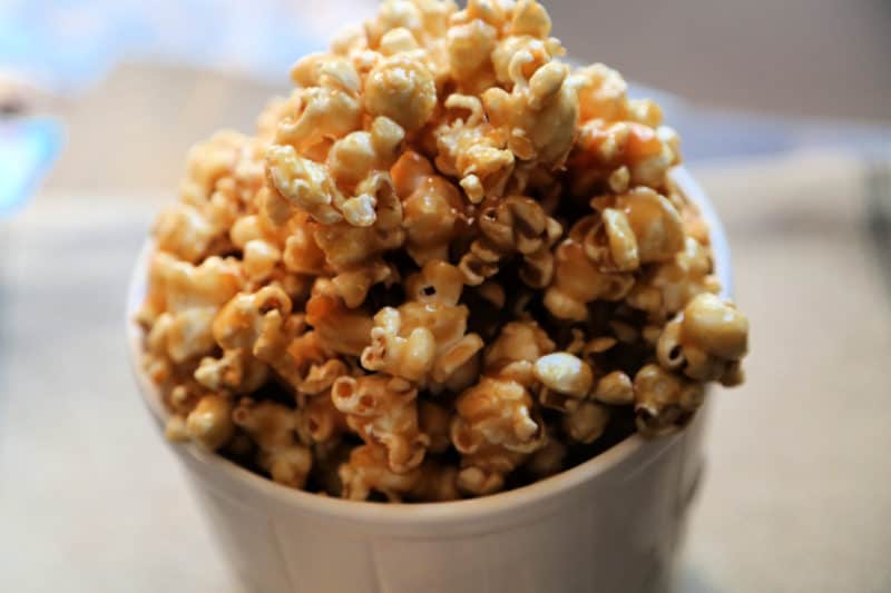 Caramel popcorn in a white popcorn bucket