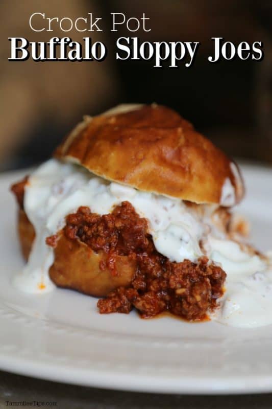Crockpot Buffalo Sloppy Joes over a white plate with sloppy joes on a bun with sauce