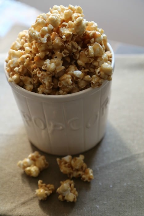 White popcorn bowl filled with caramel popcorn