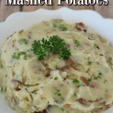Garlic Herbed Mashed Potatoes over a white bowl filled with herb mashed potatoes