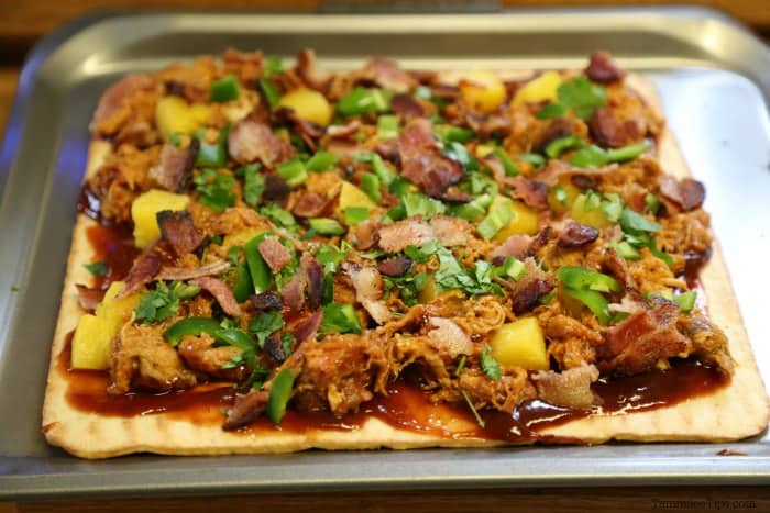 pulled pork pizza ready to bake on a baking sheet