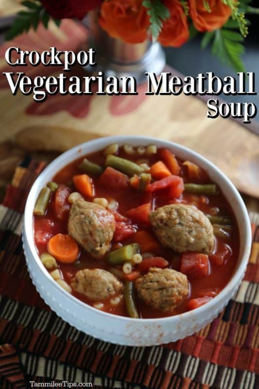 Crockpot Vegetarian Meatball Soup over a white bowl with meatballs and vegetables with flowers in the backgorund