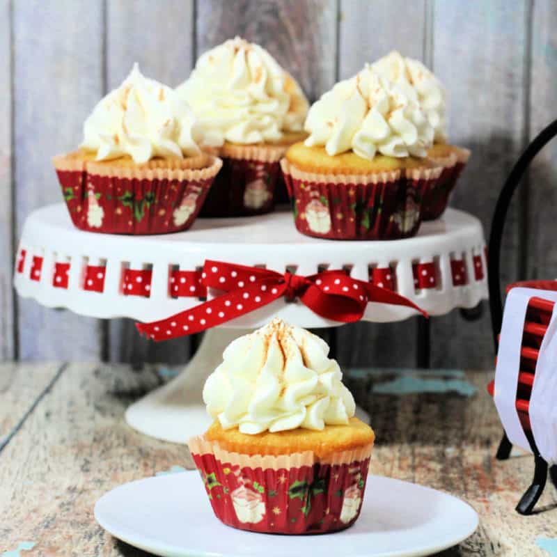 Eggnog Spice Cupcakes on a cake platter and white plate