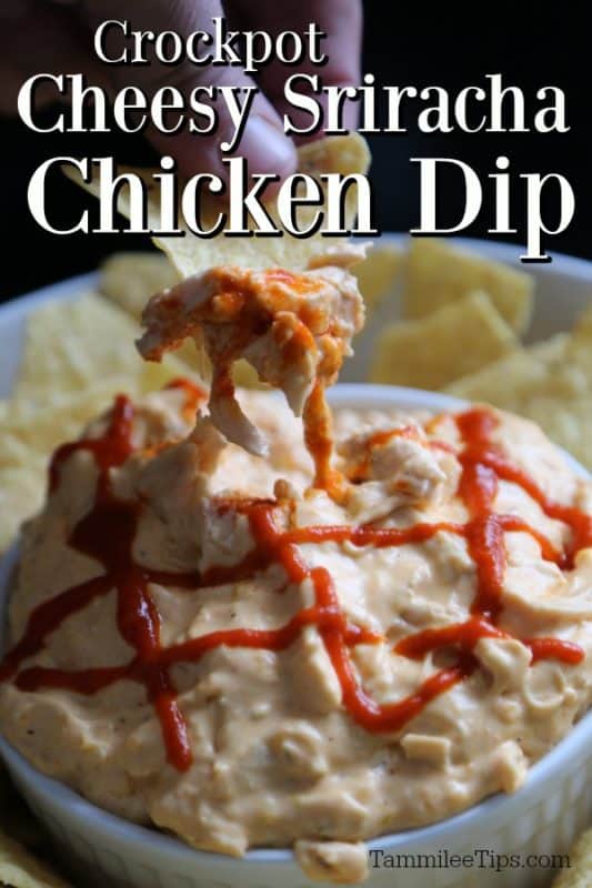 Crockpot Cheesy Sriracha Chicken Dip over a white bowl filled with dip and a hand holding a tortilla chip with dip on it. 