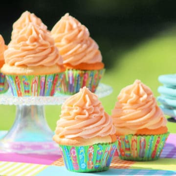 Orange Julius Cupcakes in a paper wrapper and on a cake stand