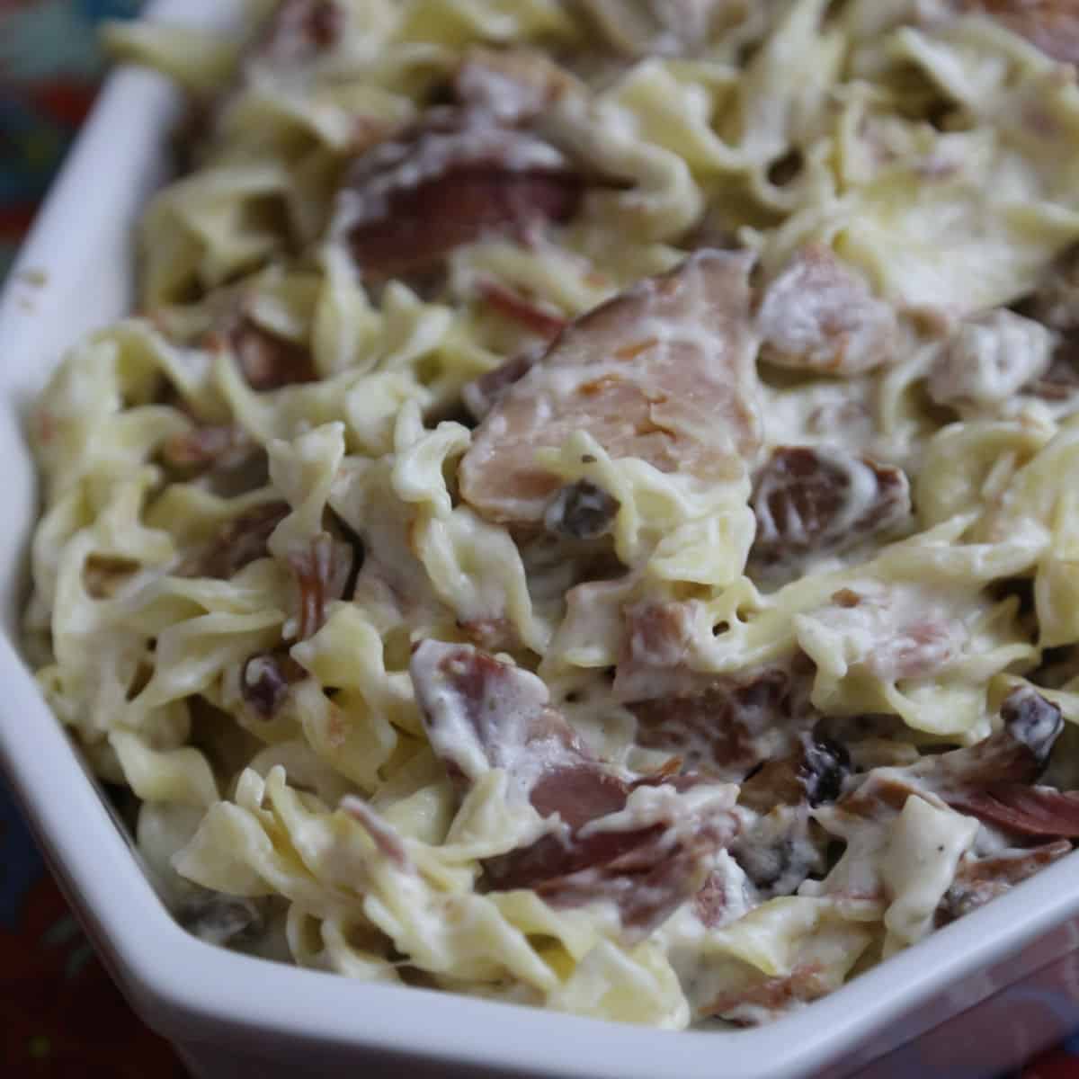 Ham and egg noodles in a white bowl