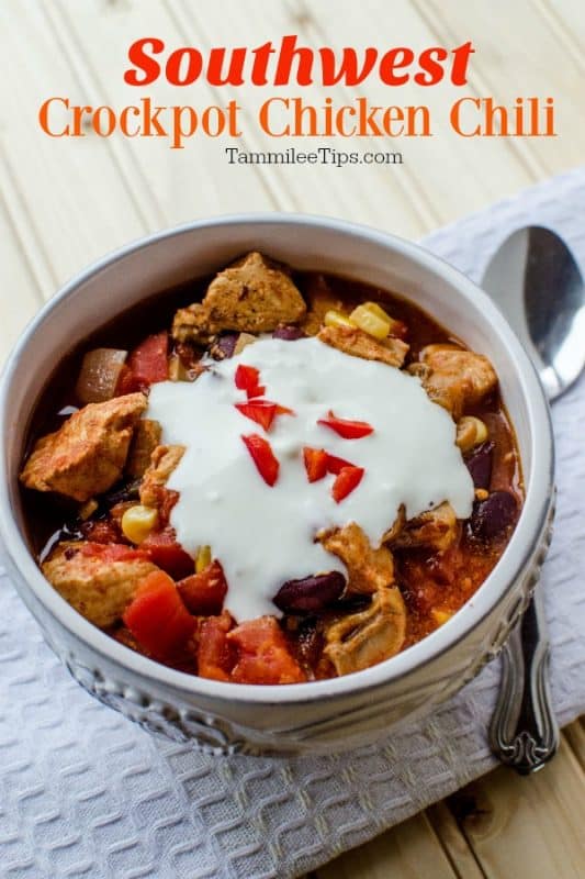 Southwest Crockpot Chicken Chili over a bowl of chili topped with sour cream, next to a silver spoon on a white napkin