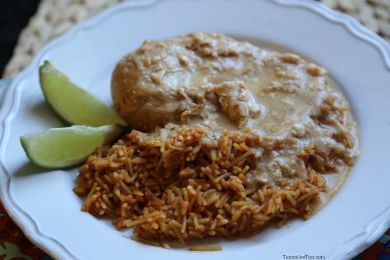 chicken and rice on a white plate with lime slices
