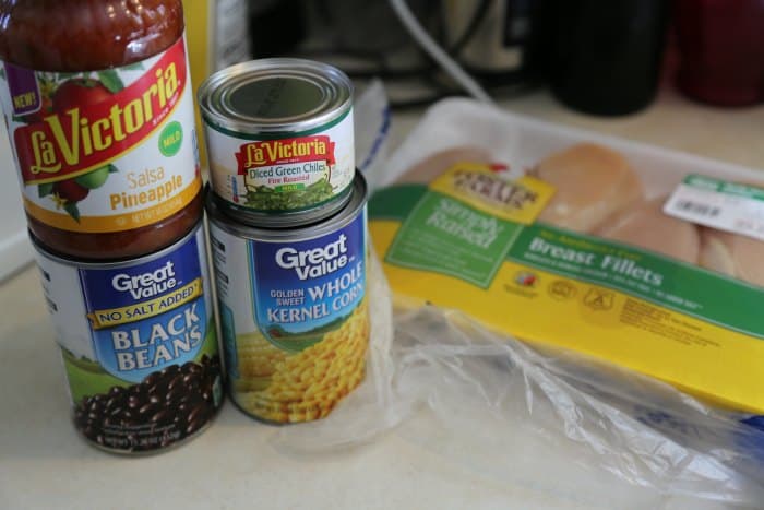 pineapple salsa, black beans, whole kernel corn, green chilis, and chicken breast on a counter