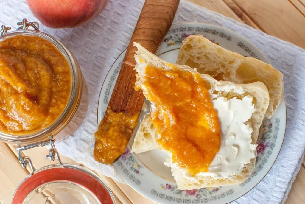 Crock Pot Peach Butter Recipe perfect for canning or enjoying fresh! This slow cooker recipe is so easy and you can easily make it a spiced peach if you want! Use your canning jars to make this into a great gift idea! This fresh peach recipe is beyond delicious and easy to make!