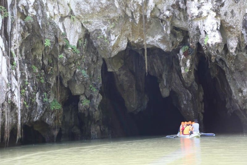 Small boat going into a underground cave