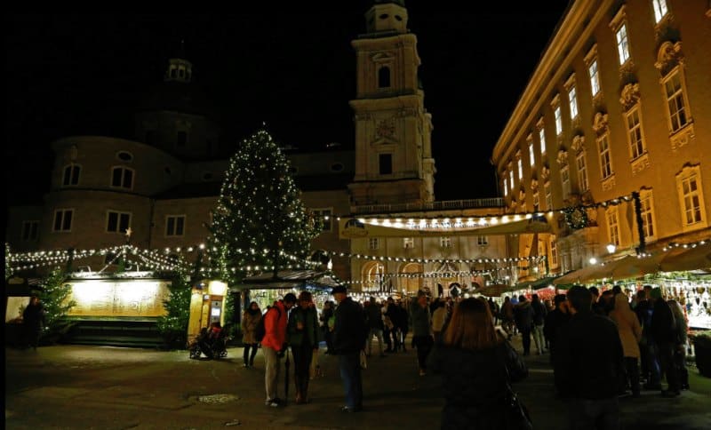 European market with Christmas tree and people lined up at stands