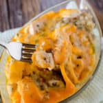 fork holding chicken stuffing casserole over a glass dish