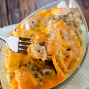 fork holding chicken stuffing casserole over a glass dish