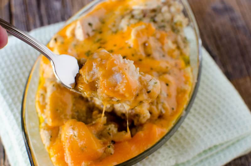 crockpot chicken and dressing in a glass bowl. Fork covered in food pulling up from the dish.
