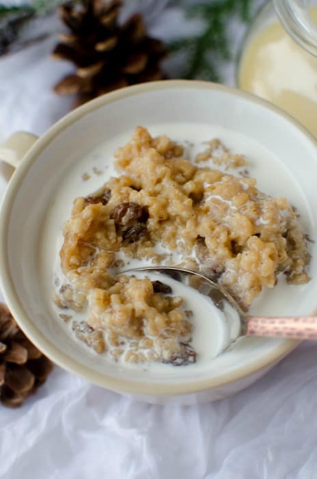Crock Pot Eggnog Oatmeal in a white bowl with a spoon in the bowl