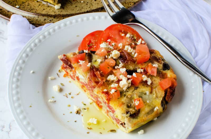 Greek frittata on a white plate next to a fork