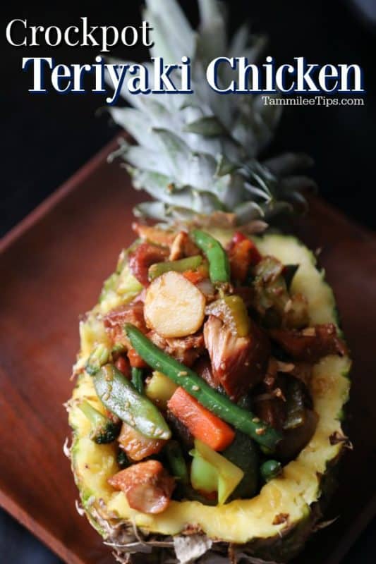 Crockpot Teriyaki Chicken over a pineapple filled with teriyaki chicken and vegetables on a wooden plate