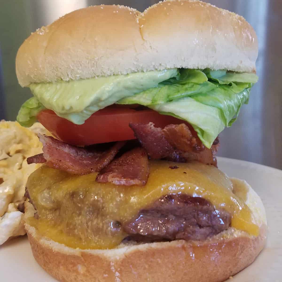 BLT Burger with Avocado Aioli on a white plate