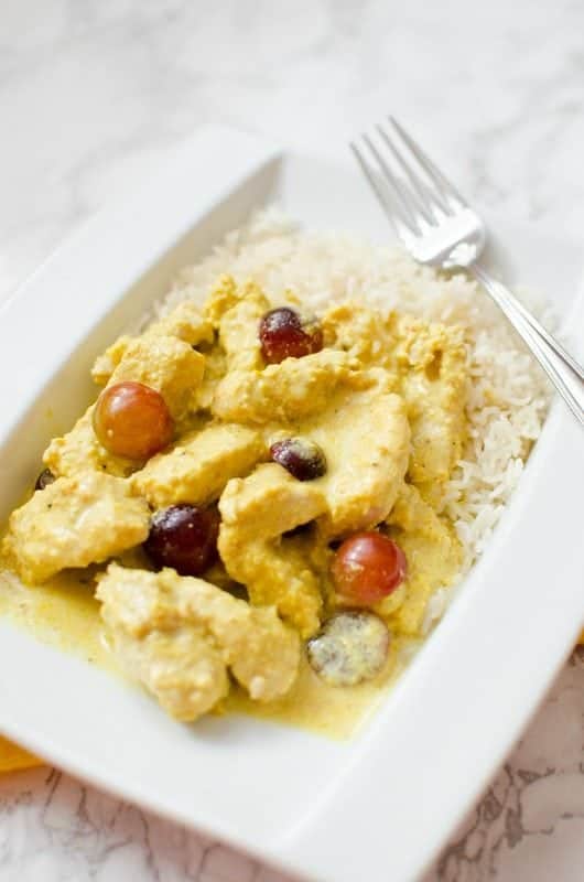 Turkey Curry on a white plate with rice next to a fork