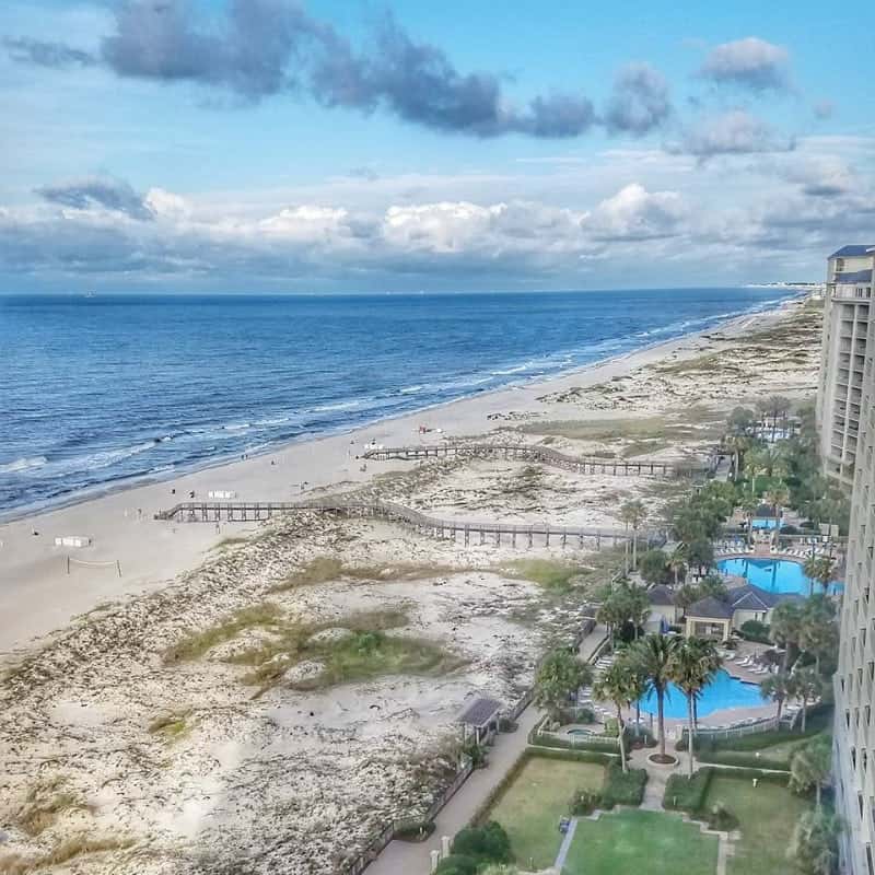 View of the Gulf of Mexico with white sand beaches, wooden boardwalk, and turquoise Place pools