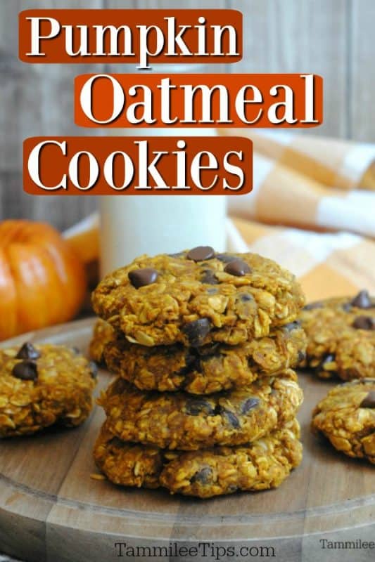 Pumpkin oatmeal cookies over a stack of cookies on a wood board with a pumpkin in the background 