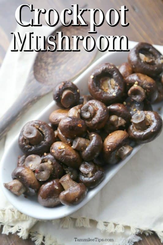 Crockpot Mushroom text written over a bowl of mushrooms with seasoning on a white napkin with a wooden spoon. 