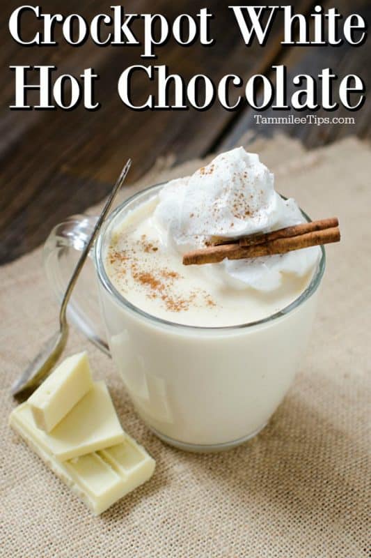 Crockpot White hot Chocolate over a glass mug filled and garnished with whipped cream and a cinnamon stick. 